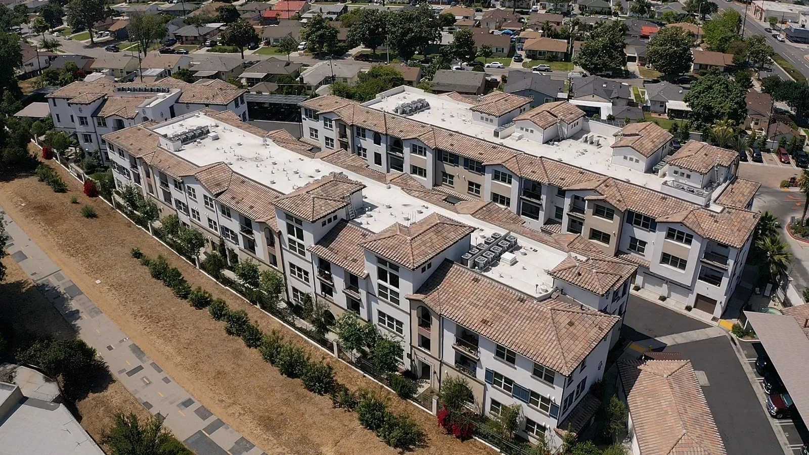 Aerial view of the Cierra Apartments in Whittier with S tile and white TPO single-ply roofs