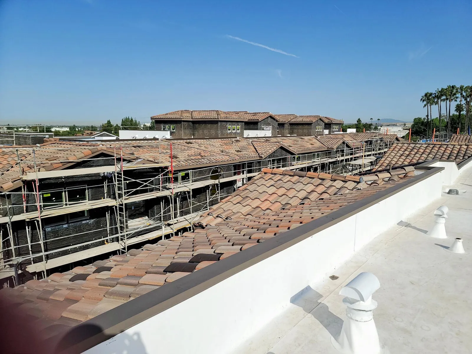 Multifamily new construction with S tile and white low-slope roof sections